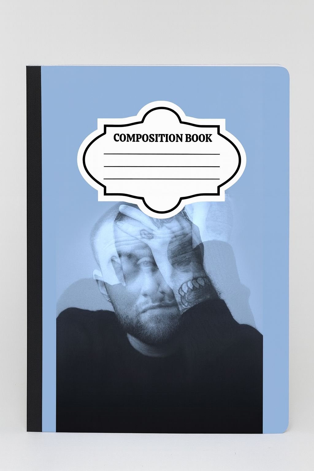 A composition notebook with a blue-toned artistic portrait of Mac Miller on the cover, blending thoughtful expression and double exposure effect.