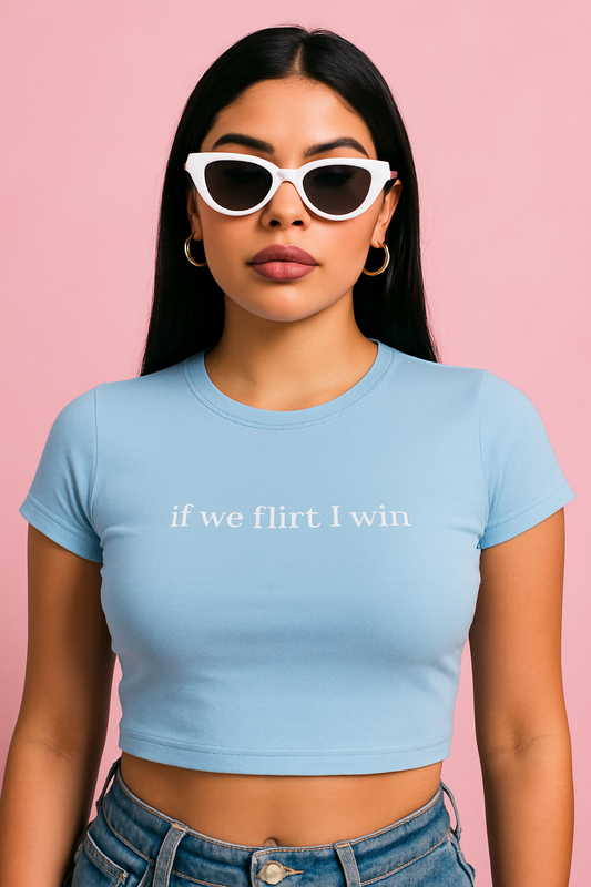 Woman wearing light blue crop top with text “if we flirt I win” — bold baddie aesthetic shirt.