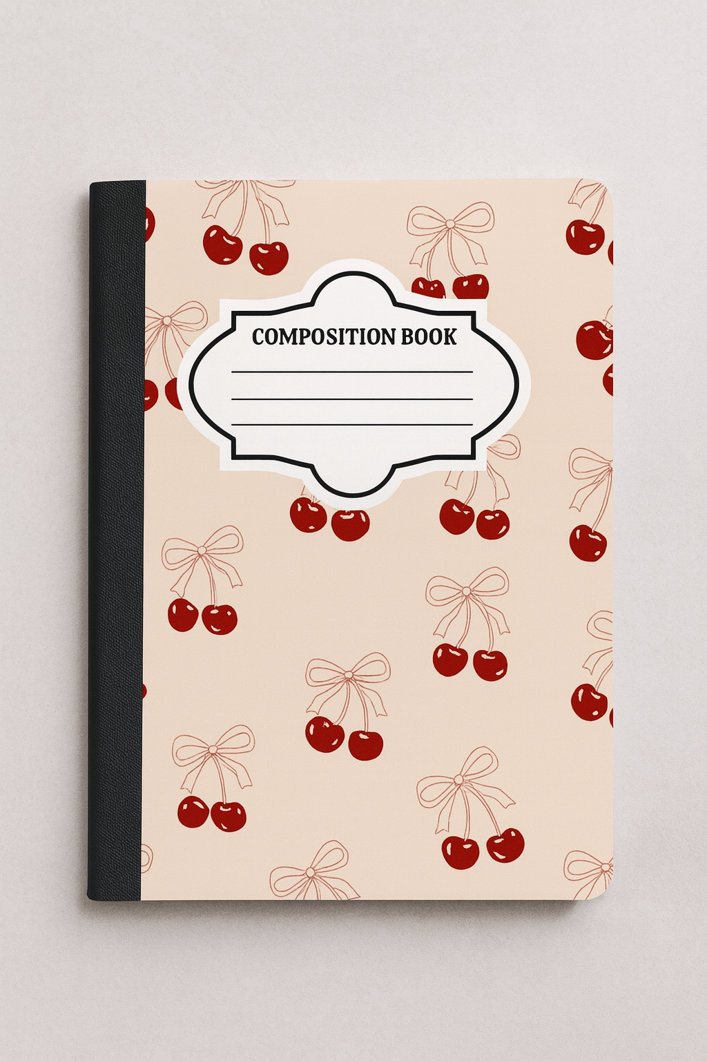 Composition notebook with beige cover featuring red cherry and bow pattern, black spine, and white label that reads Composition Book