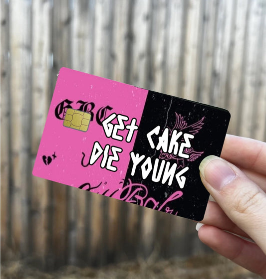 Two-tone pink and black credit card cover with bold white graffiti-style text reading “Get Cake Die Young” and wing graphic, fits standard card size
