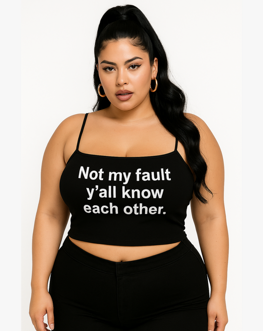 Confident woman wearing a black spaghetti strap crop top with bold white text that says “Not my fault y’all know each other”